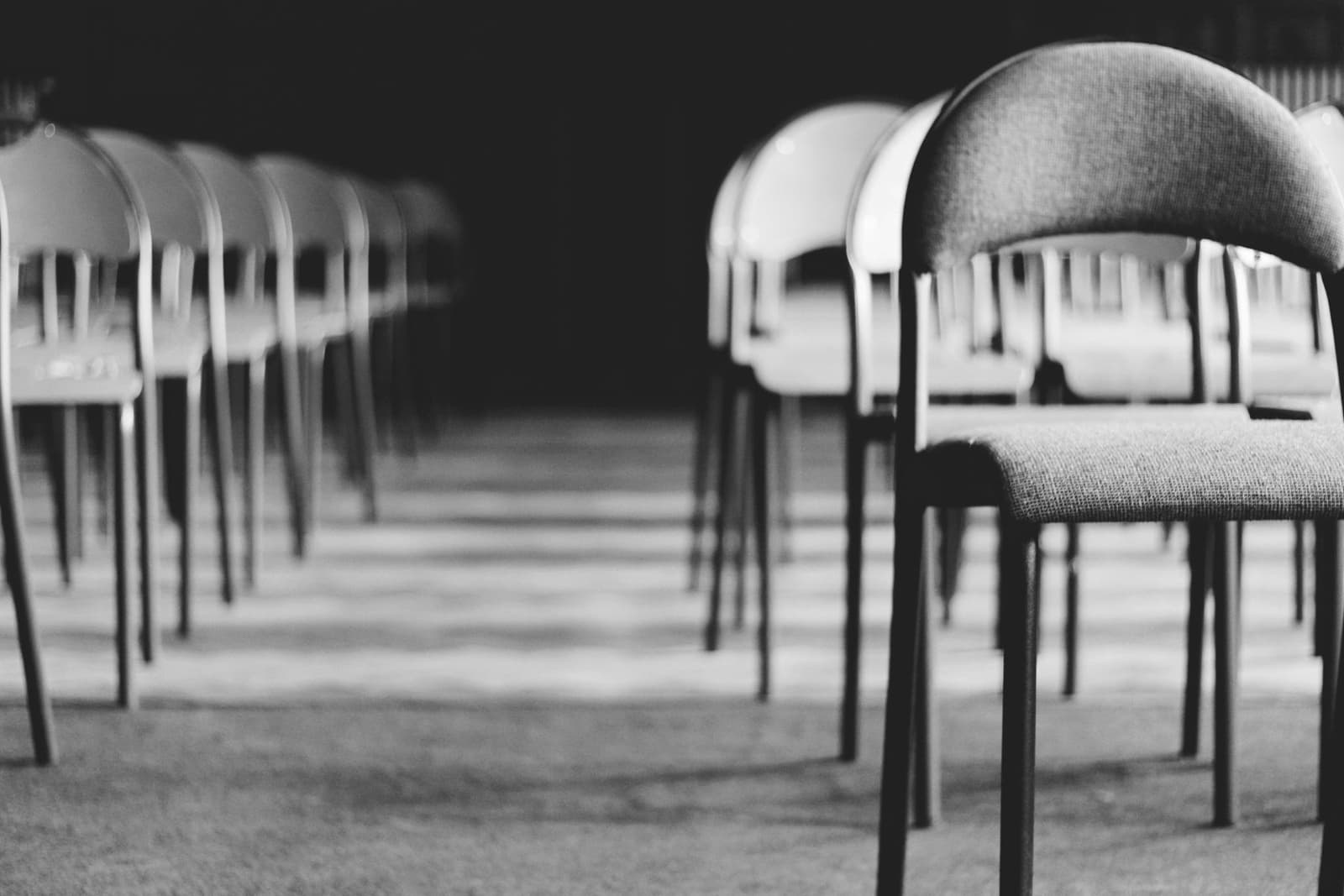Rows of empty chairs in a meeting room, in black and white, under the headline Annual meetings