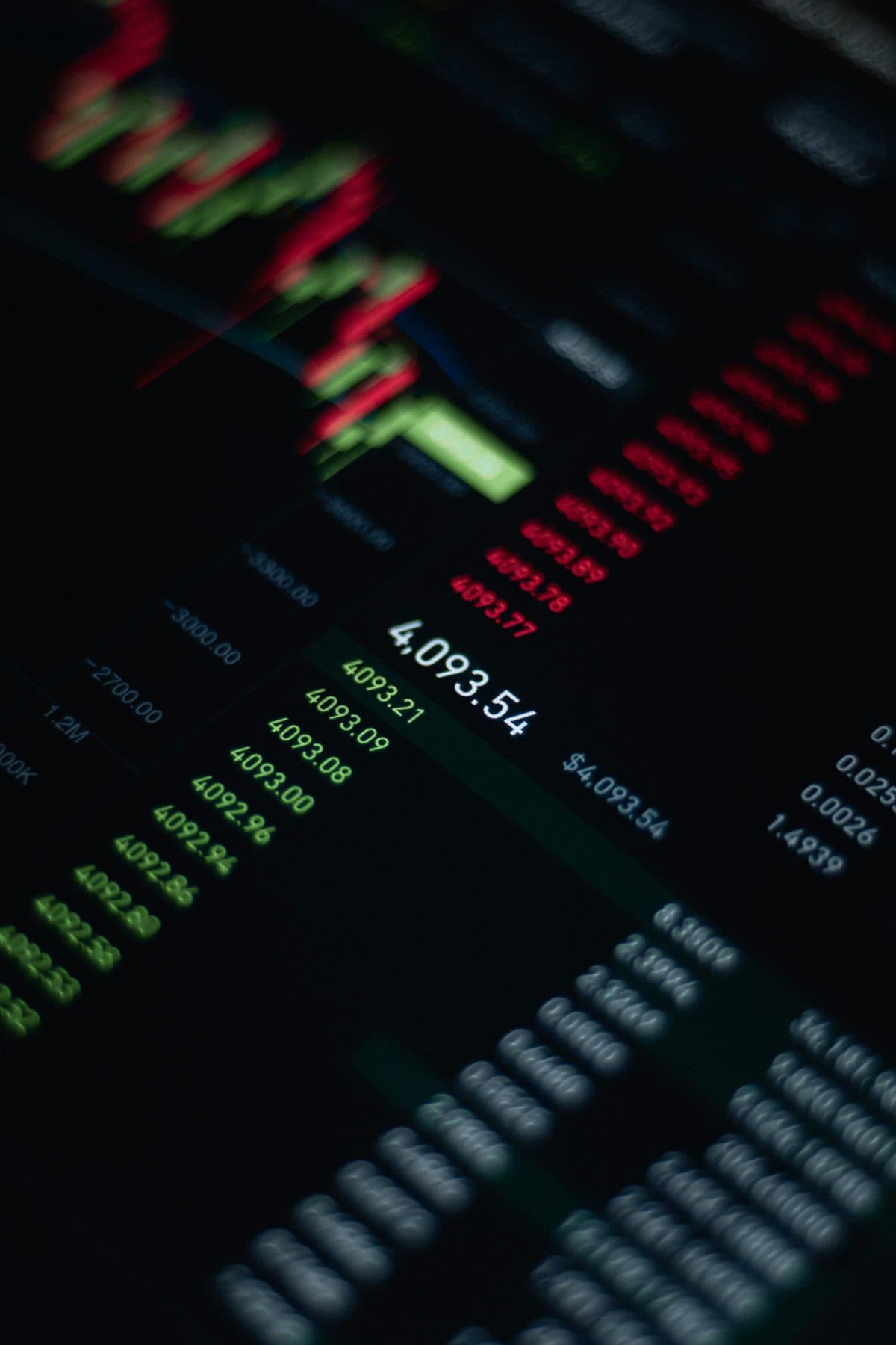 A dark trading screen showing columns of red and green price levels, under the headline The Spread