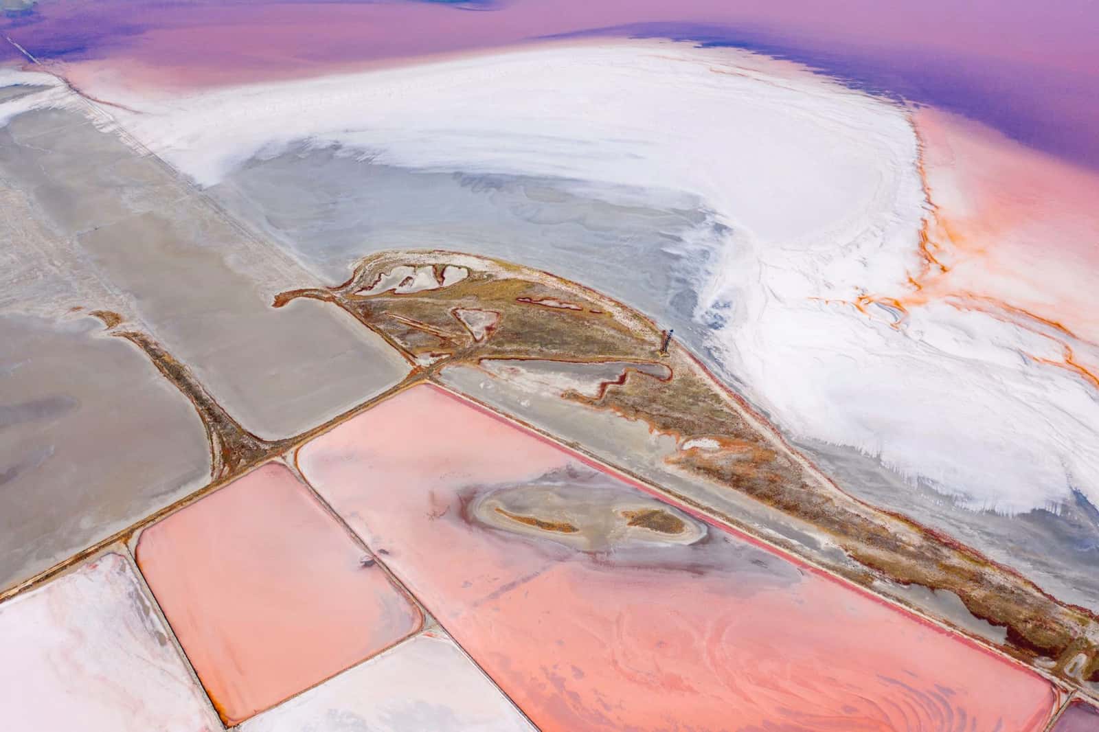 Aerial view of pink and white salt evaporation ponds, under the headline Lithium