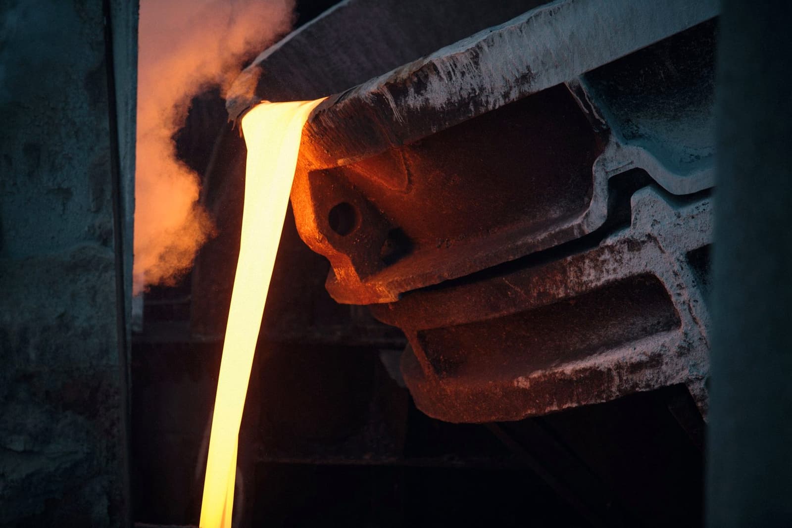 Molten metal pouring from a ladle in a dark industrial plant, under the headline TC/RCs
