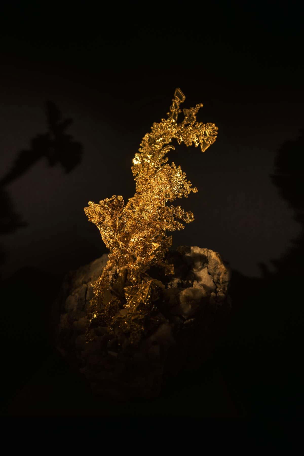 A gold nugget lit against a black background, under the headline Gold